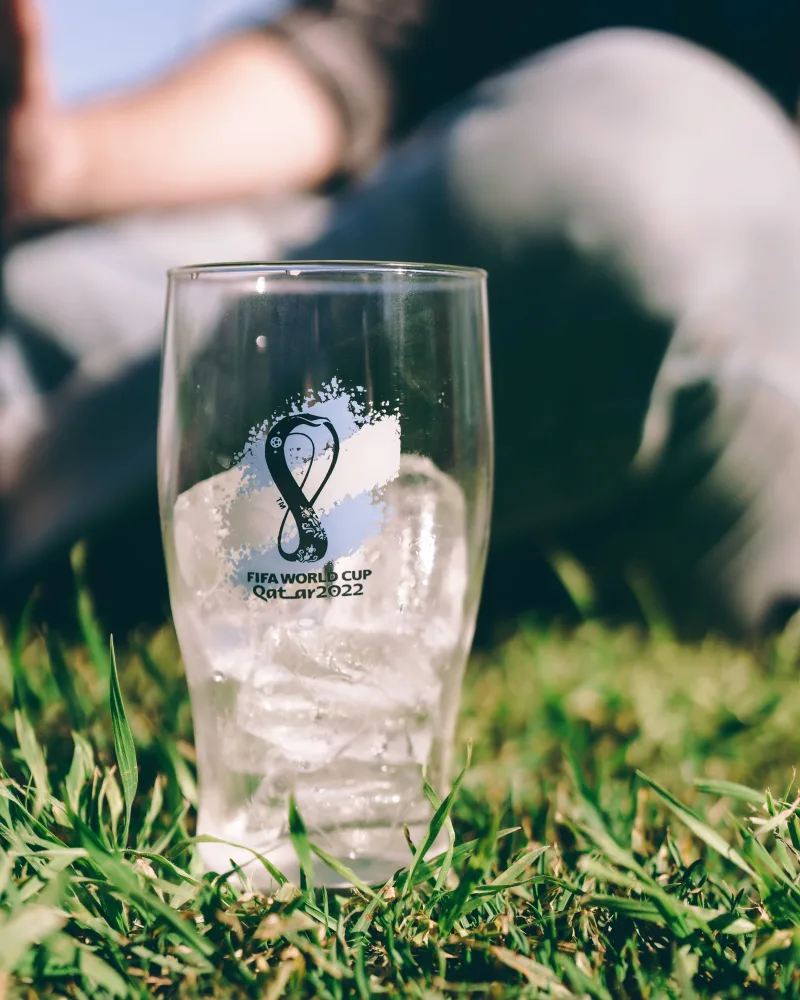 Copa Mundial de la FIFA 2022 con vaso de vidrio lleno de hielo sobre el césped en Buenos Aires, ambiente al aire libre.