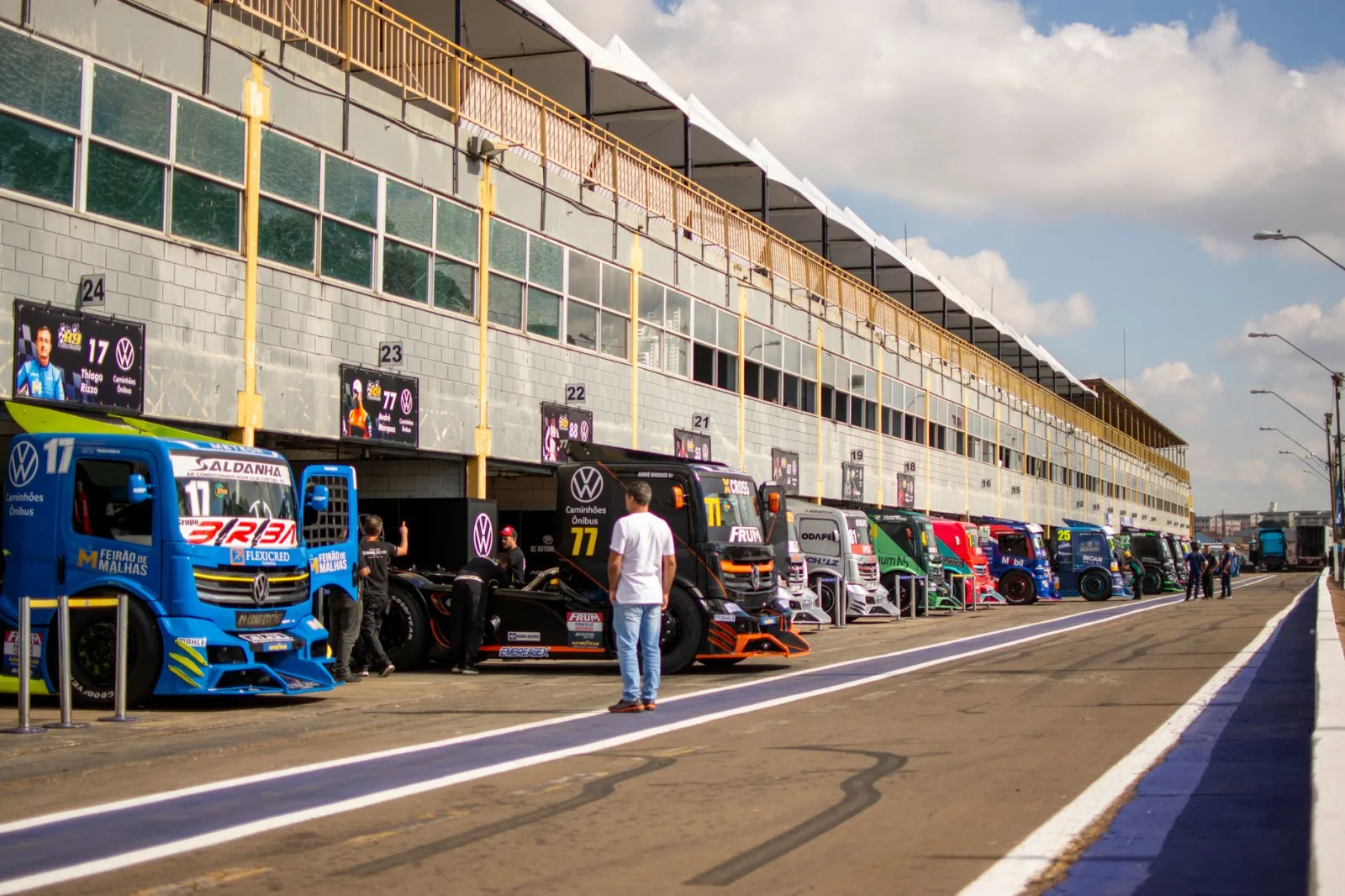 Varios camiones alineados en el pit lane de Londrina durante un evento de automovilismo.