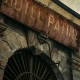 Letrero desgastado del Hotel Patria en un edificio antiguo de Palermo, Sicilia, que evoca el encanto de otra época.