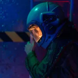 Astronauta con casco contemplando un viaje espacial en el ambiente oscuro y sombrío de una nave espacial.