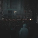 Una gran multitud se reúne para una manifestación en una calle poco iluminada de Bristol, Inglaterra.