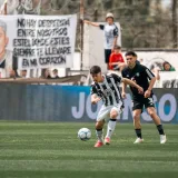 Soccer players competing fiercely during a match in an outdoor stadium.