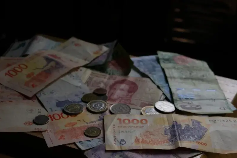 A collection of various international banknotes and coins scattered on a table.