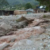 Consecuencias de una inundación en una zona rural de Mocoa, Colombia, con escombros y destrucción.
