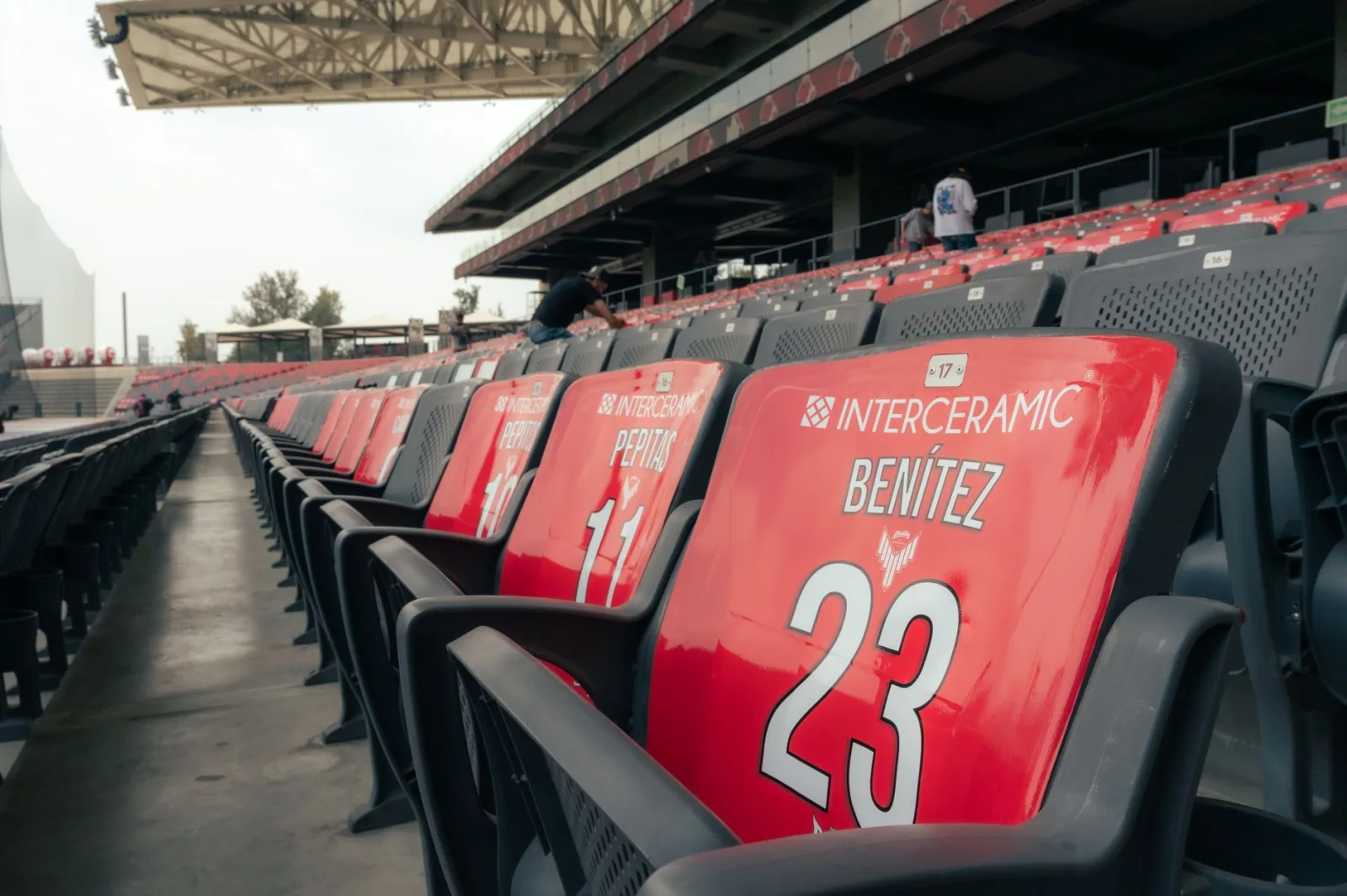 Asientos vacíos en un estadio moderno al aire libre, ideales para eventos deportivos.