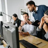 Un equipo diverso de agentes de un centro de llamadas colabora en una oficina moderna.
