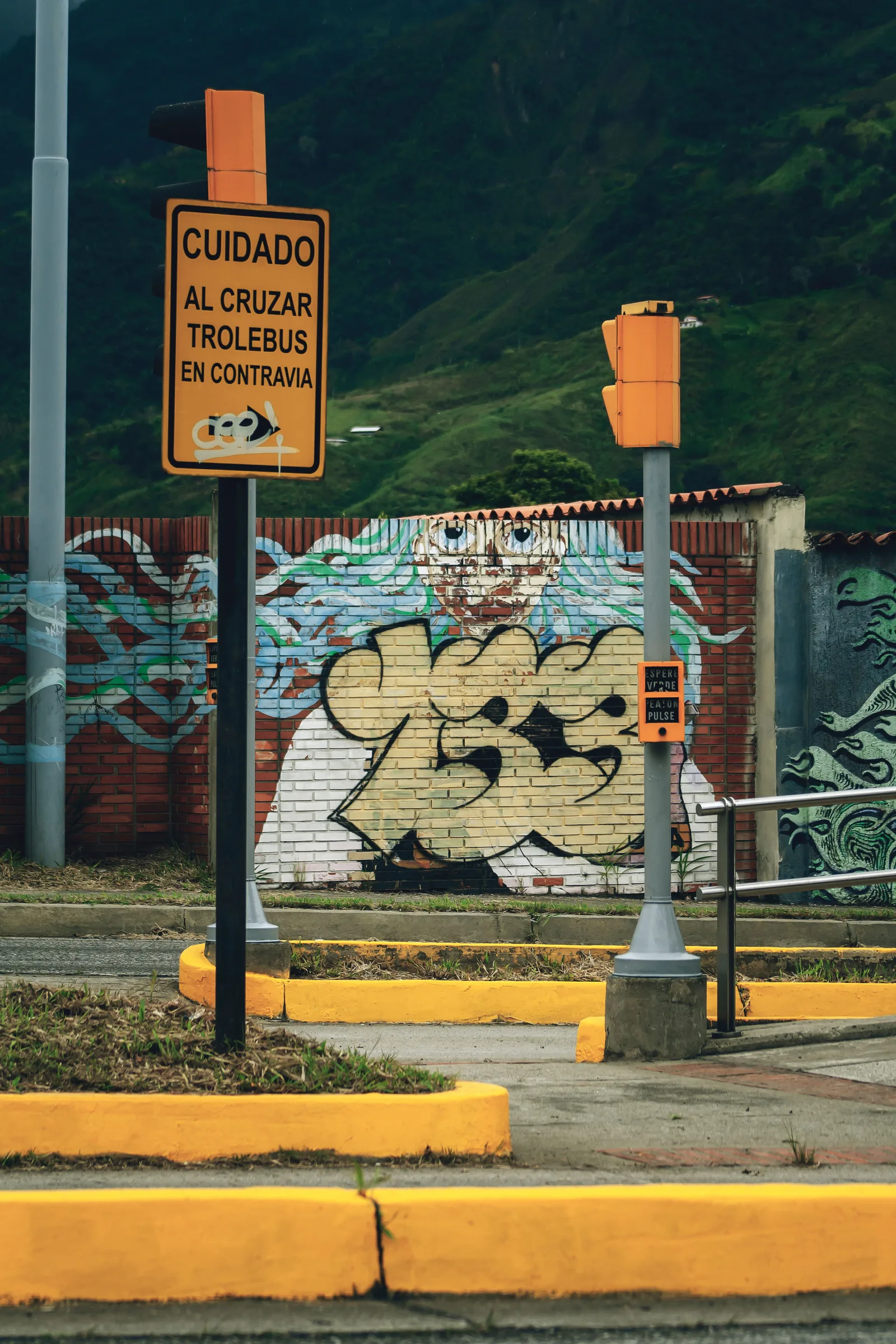 Street art mural and road signs reflecting cultural cityscape in Mérida, Venezuela.