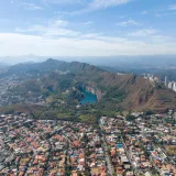 Vista aérea panorámica de Belo Horizonte, donde se aprecian la Serra do Curral y el desarrollo urbano que rodea un lago en Minas Gerais, Brasil.