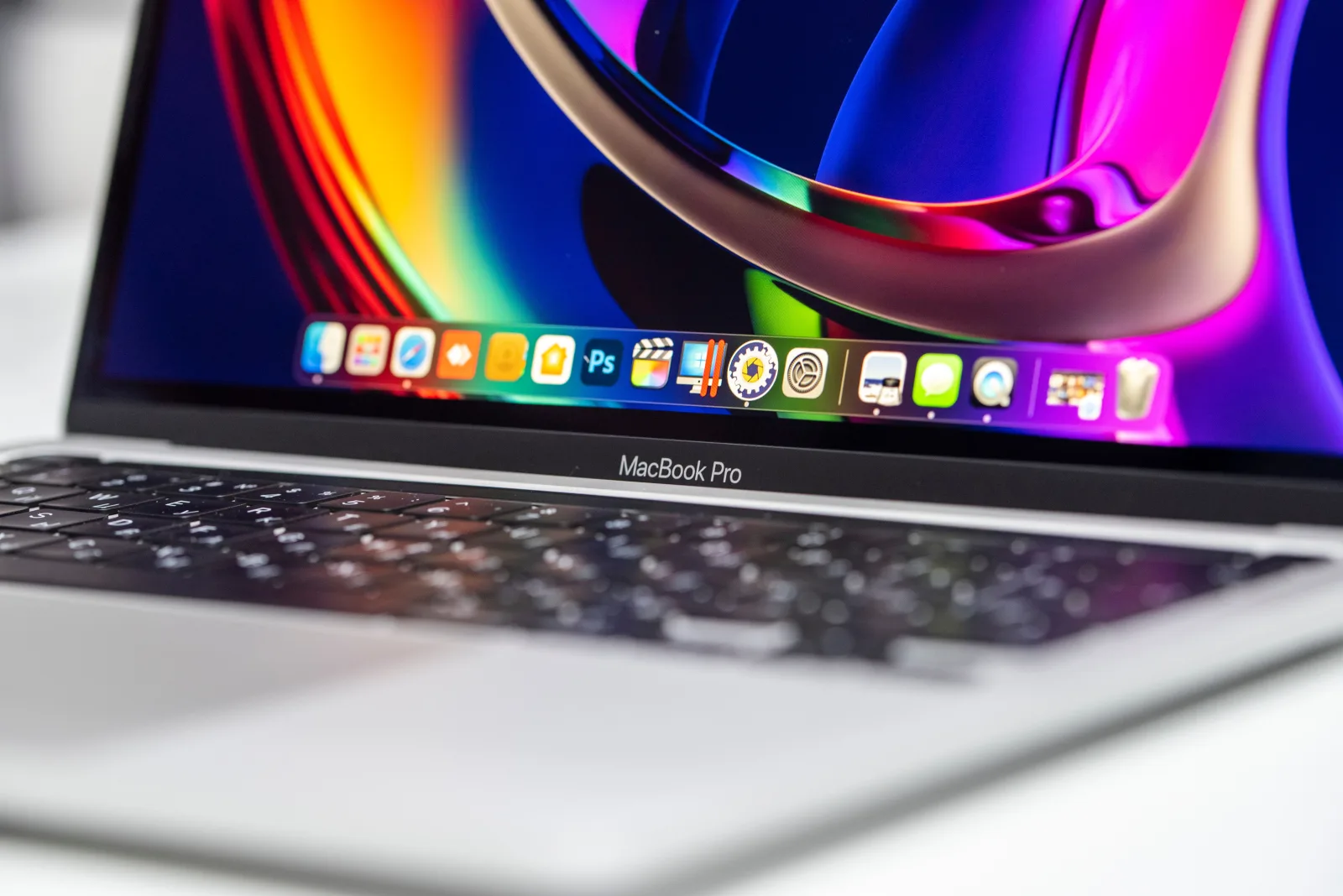 Primer plano vibrante de un MacBook Pro que muestra su pantalla y teclado de colores.