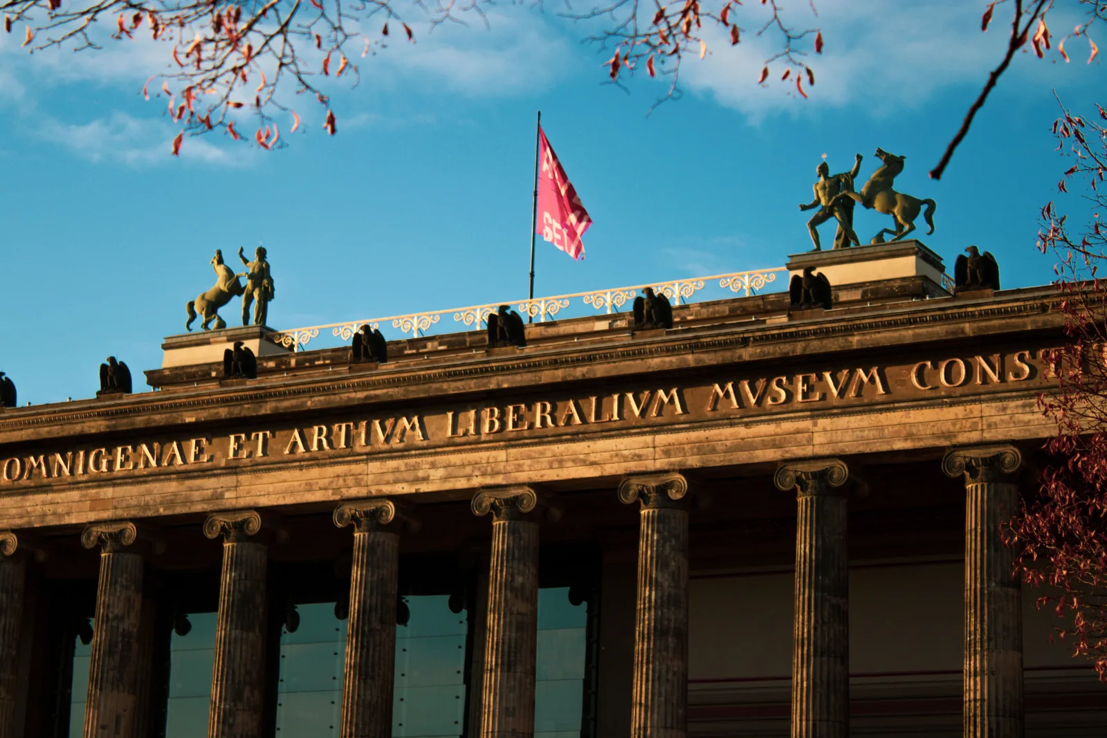 Elegante fachada del Altes Museum de Berlín, con la luz del sol iluminando su arquitectura clásica.