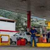 A man standing near fuel pumps at a gas station in Costa Rica, illustrating daily life.