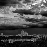 Una cautivadora vista en blanco y negro del perfil urbano de Madrid bajo nubes dramáticas.