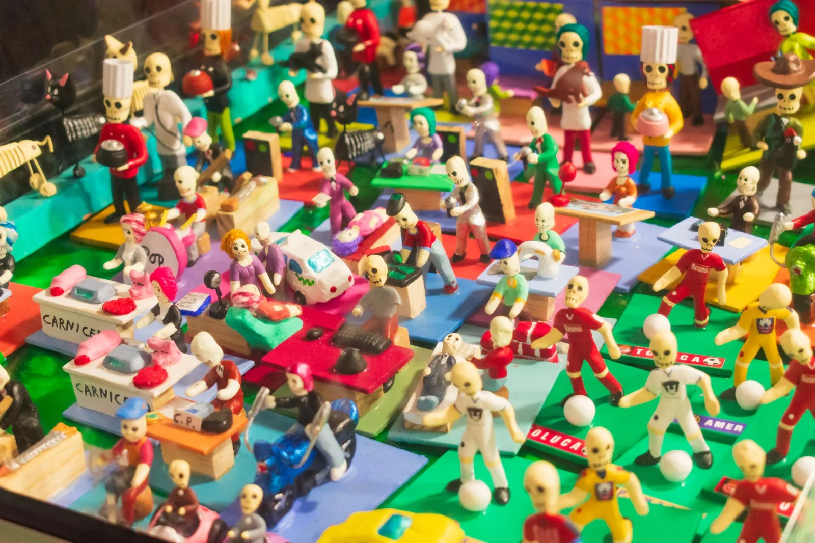 Escena vibrante en miniatura que representa una celebración del Día de Muertos con figuras de esqueletos en Toluca.