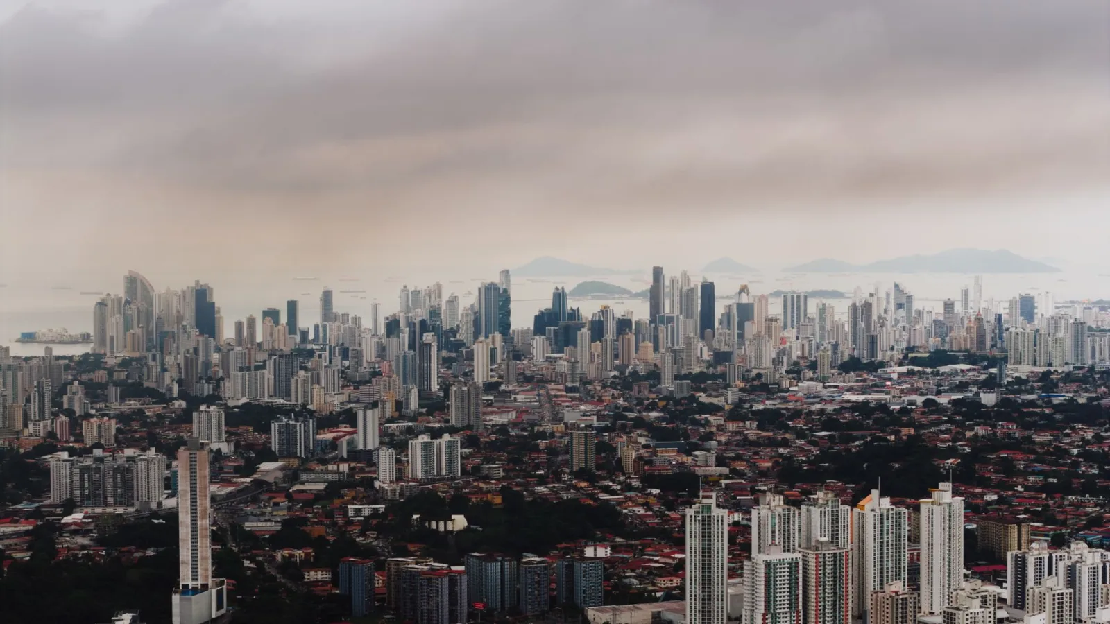 Impresionante vista aérea del horizonte de Ciudad de Panamá, con densos rascacielos y un paisaje costero de fondo.