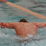 Back view of a swimmer competing in a pool in San Luis Potosí, showcasing water sports dynamics.