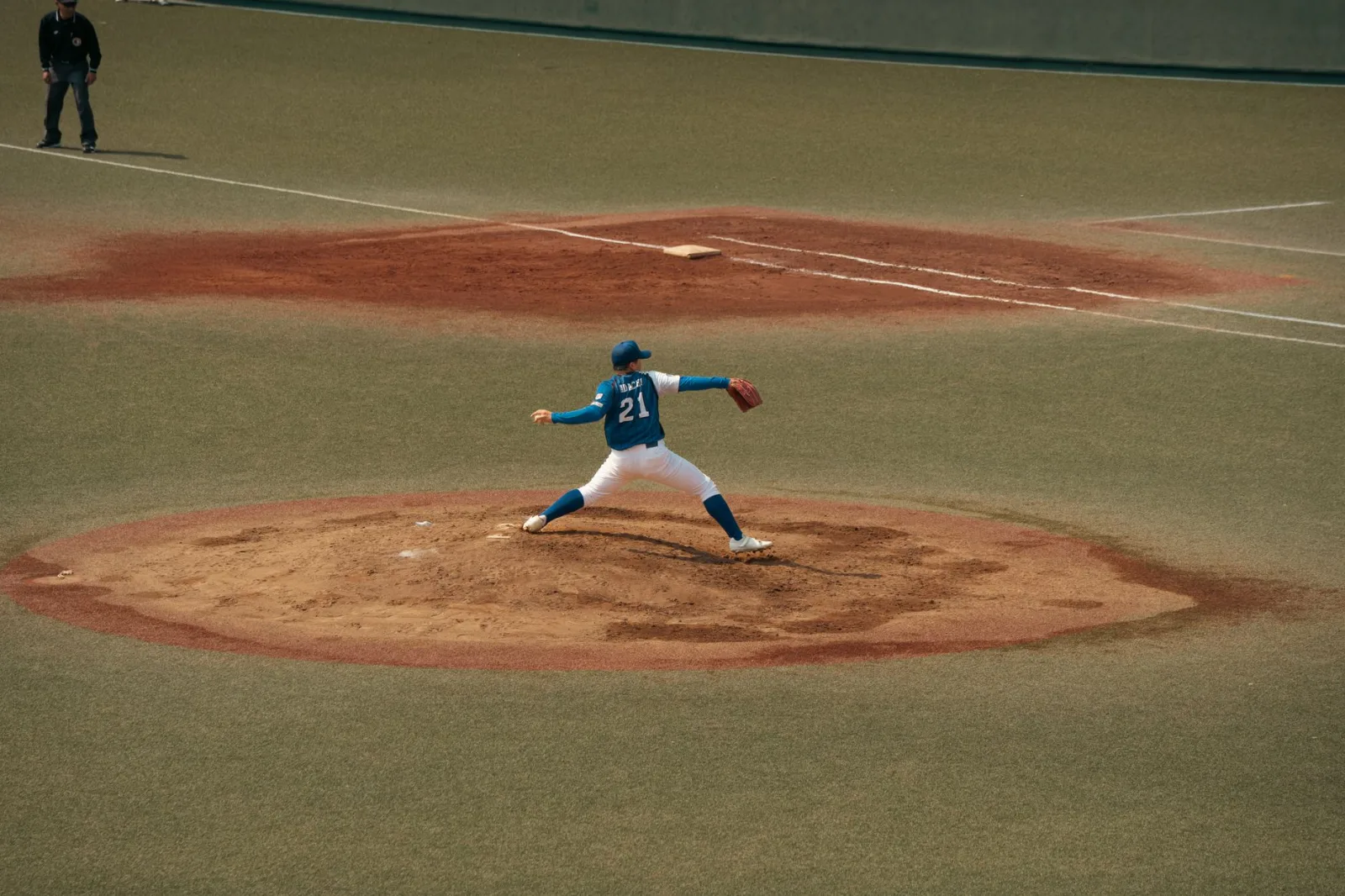Jugador de béisbol en medio de un lanzamiento durante un partido en un campo de béisbol de Tokio. Capturando la intensidad y la concentración del deporte.