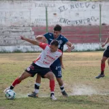 Jóvenes atletas participan en un partido competitivo de fútbol en una cancha de césped, demostrando habilidad y trabajo en equipo.