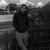 A black and white portrait of a man in a hoodie on a wooden pier in San José Chiapa, Mexico.