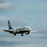 Avión de Ryanair en pleno vuelo con un cielo nublado de fondo, que ilustra los viajes aéreos.