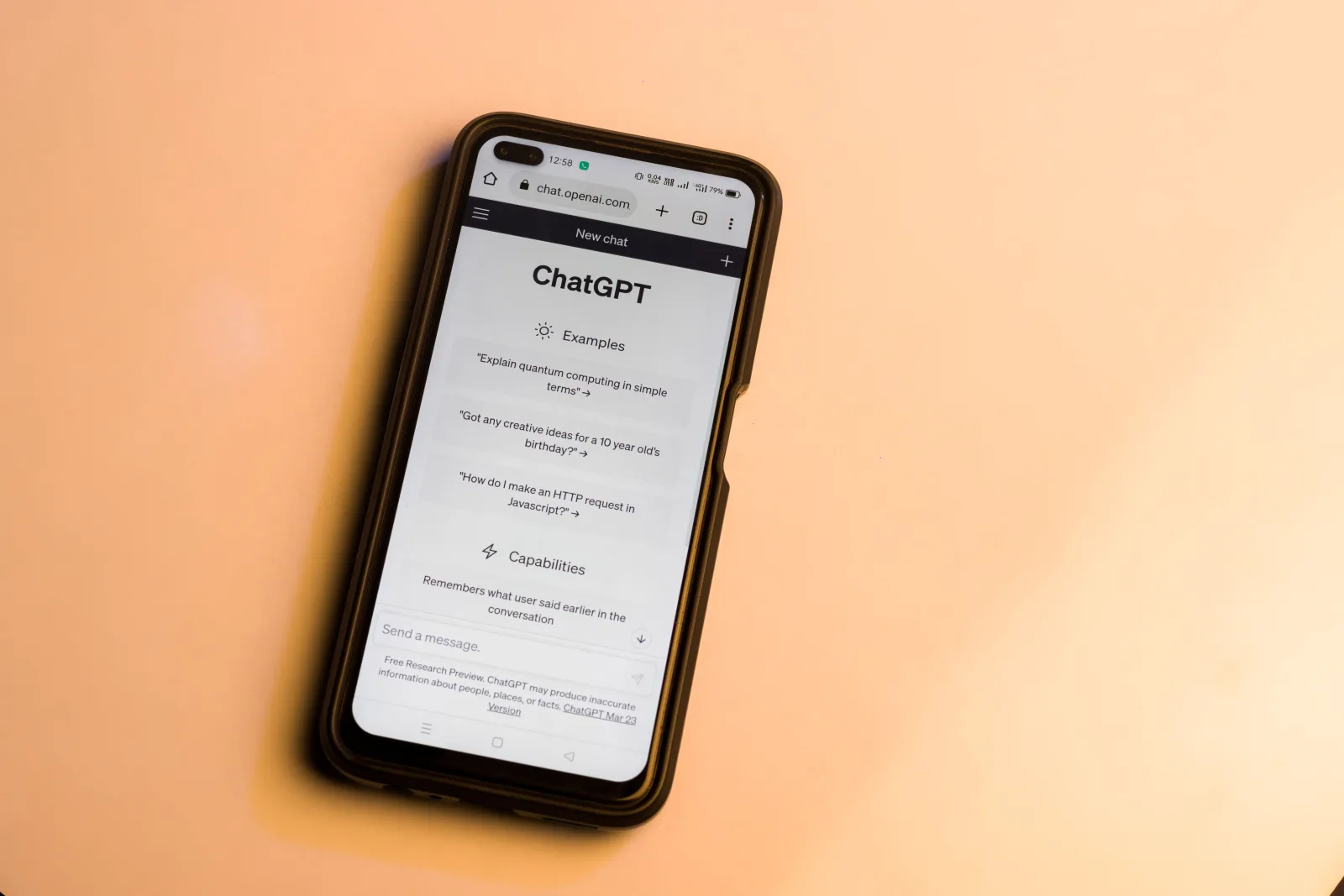 Un smartphone muestra el sitio web de ChatGPT en tonos cálidos, destacando la tecnología de inteligencia artificial.