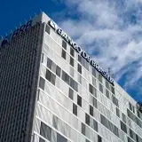Skyward view of the Banco de Brasília, an iconic modern building in Brazil's capital, under a clear sky.