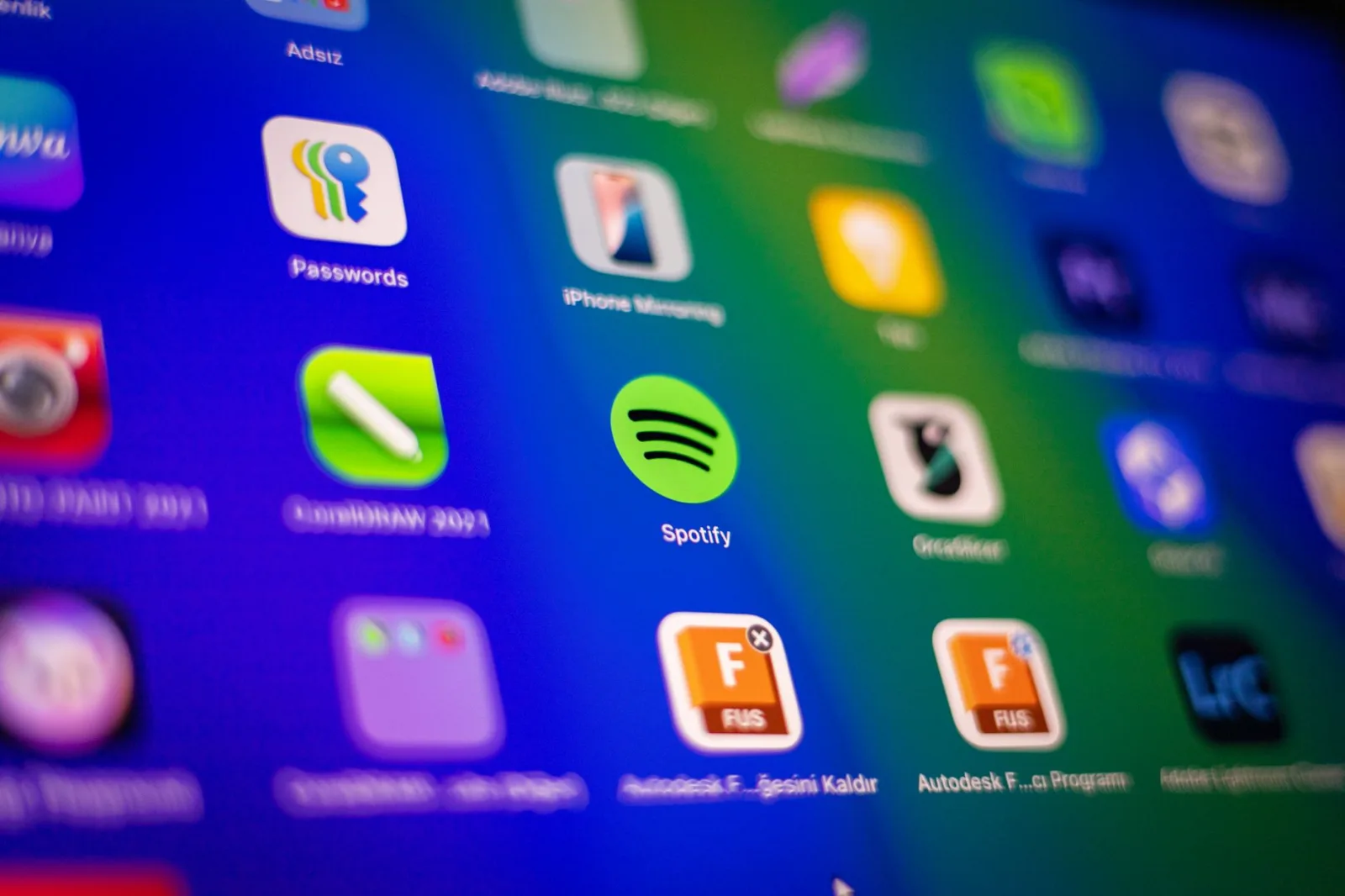 Primer plano desenfocado de vibrantes iconos de aplicaciones en la pantalla de un smartphone que muestra Spotify y más.