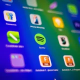 Primer plano desenfocado de vibrantes iconos de aplicaciones en la pantalla de un smartphone que muestra Spotify y más.