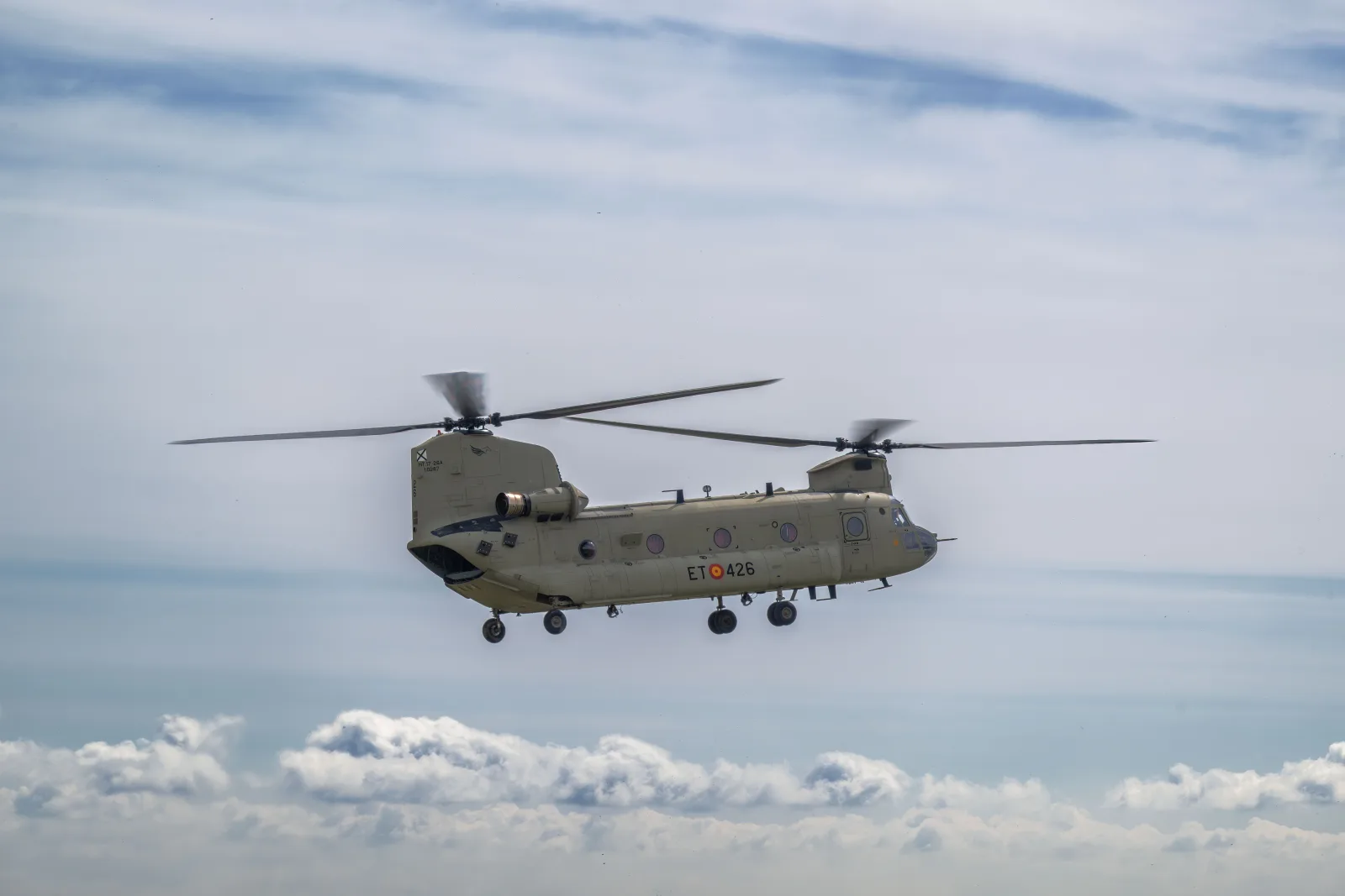 Vista lateral de un helicóptero militar surcando un cielo nublado, mostrando la tecnología de aviación.