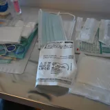 Primer plano de diversos suministros médicos sobre una mesa estéril en un entorno sanitario.