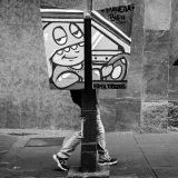 Black and white photo showcasing street art and a pedestrian in Caracas, evoking an urban scene.