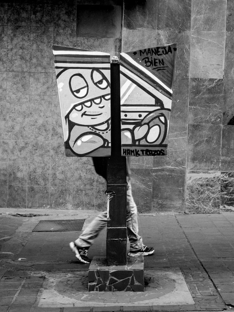 Black and white photo showcasing street art and a pedestrian in Caracas, evoking an urban scene.