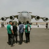 Un avión militar Boeing C-17 exhibido en un evento en un aeródromo mientras la gente lo observa.