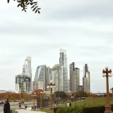 Modern skyscrapers of Buenos Aires, Argentina, viewed from the park with street and people in foreground.