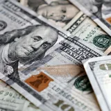 Una foto detallada de billetes estadounidenses de cien dólares, mostrando a Benjamin Franklin.