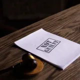 Un martillo judicial junto a un documento de «No culpable» sobre una mesa de madera, simbolizando la justicia.