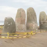 Sculpture of fingers emerging from sand on Playa Brava beach, Uruguay.