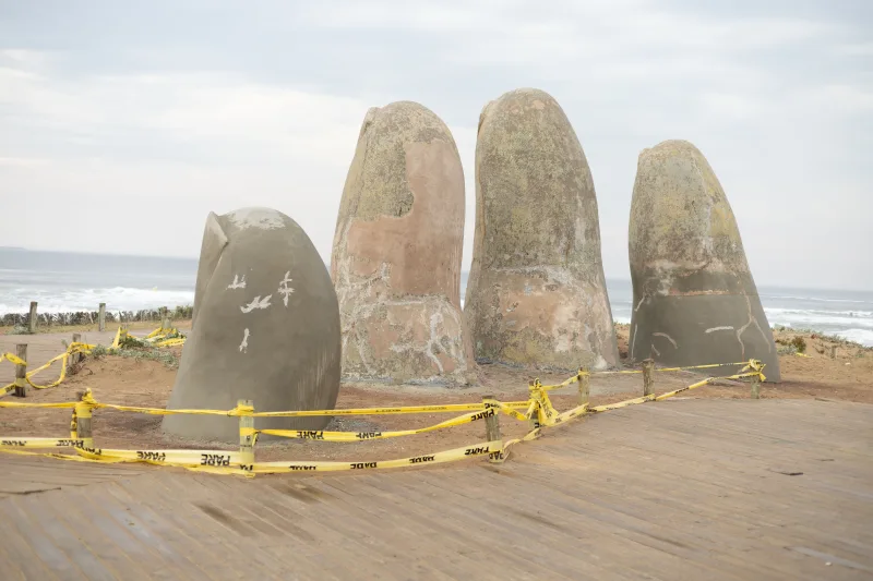 Sculpture of fingers emerging from sand on Playa Brava beach, Uruguay.