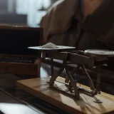 Báscula clásica de estilo vintage con un pequeño montón de polvo blanco colocada en interiores sobre una superficie de madera.