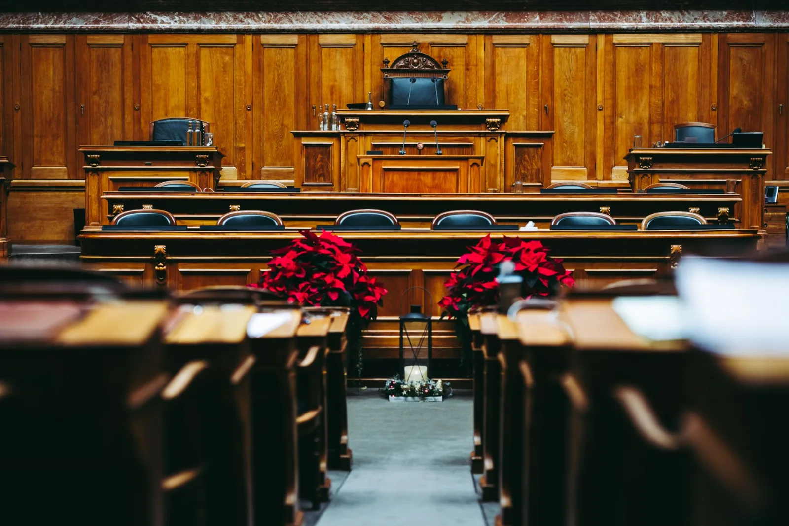 Sala de audiencias de madera, espaciosa y elegante, con asientos vacíos, ubicada en Berna, Suiza.