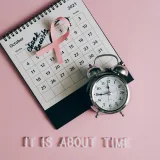 Calendario con cinta rosa, un despertador y el texto "Revisa tus senos" simboliza la Concienciación sobre el Cáncer de Mama.