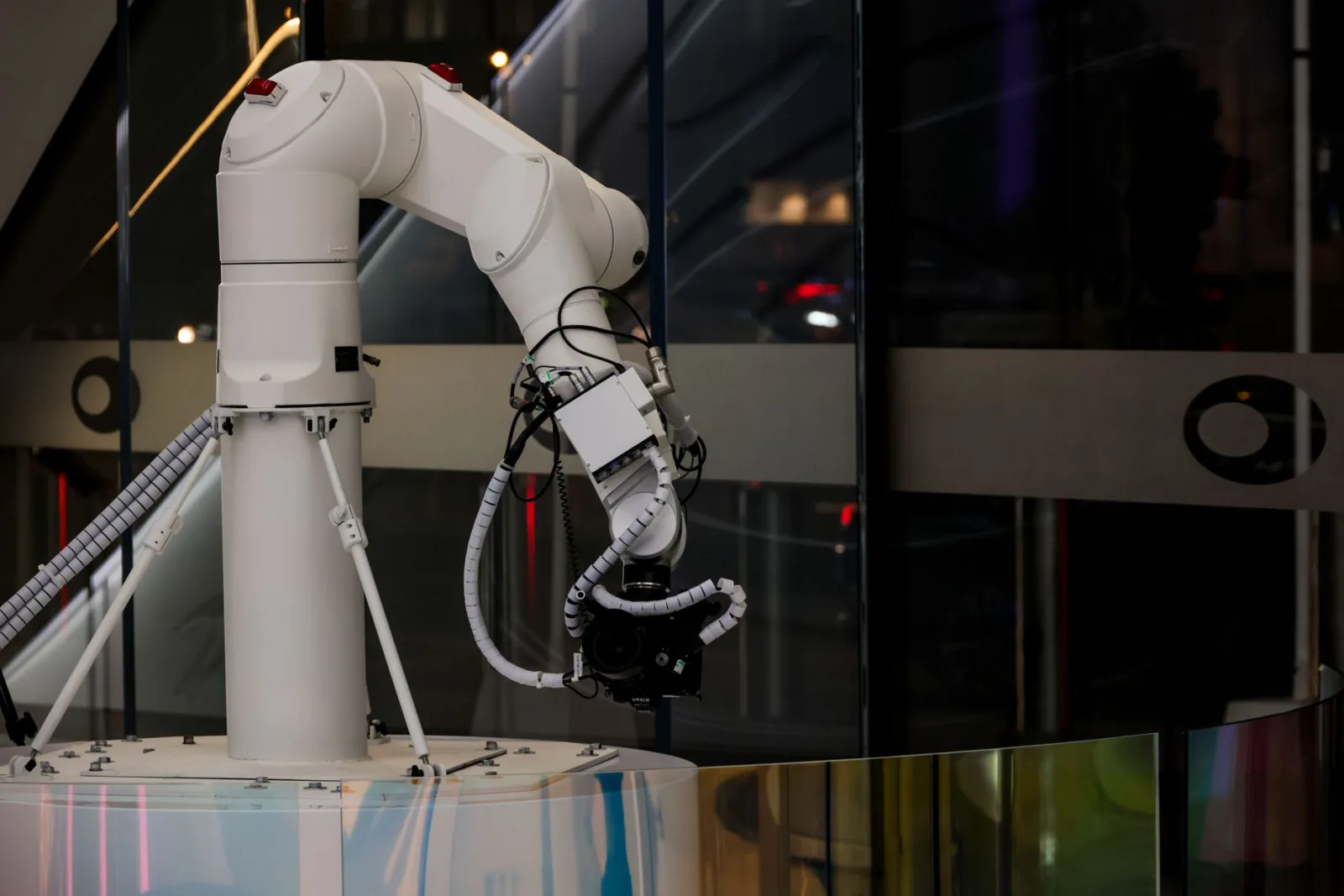 Un brazo robótico blanco en funcionamiento en interiores, con un diseño moderno y tecnología avanzada.