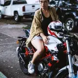 Una mujer sentada en una motocicleta en Santo Domingo, capturando vibras urbanas.