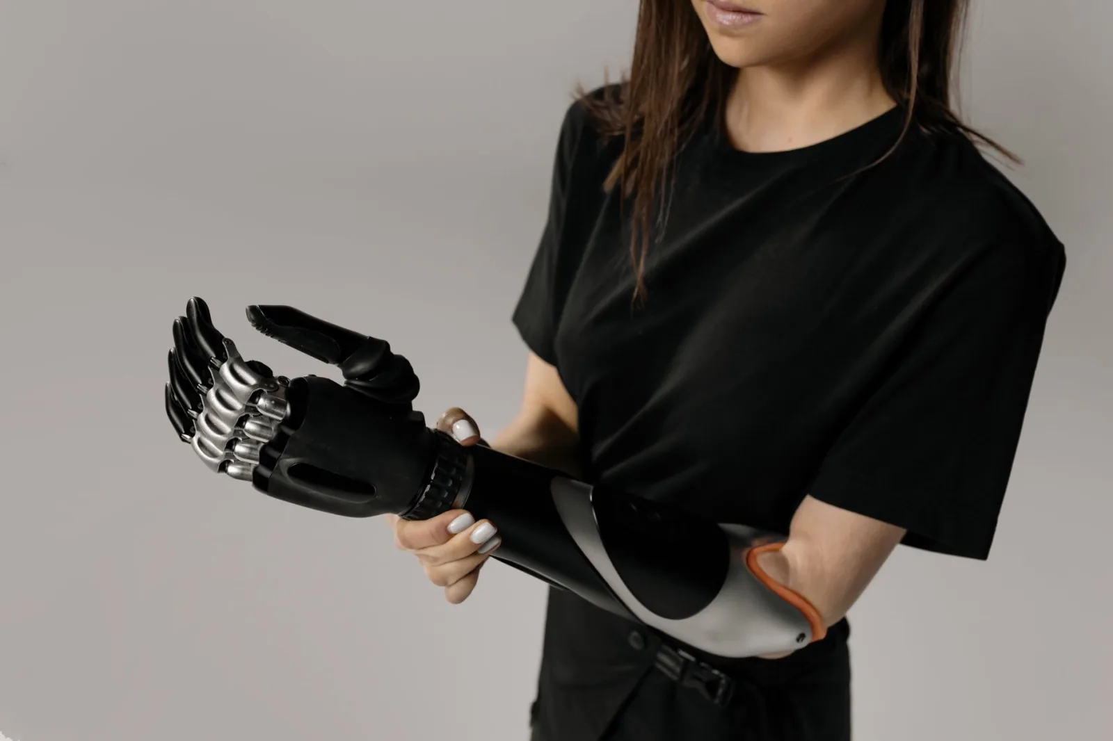 Primer plano de una mujer ajustando su prótesis biónica de última generación, que muestra un diseño innovador.