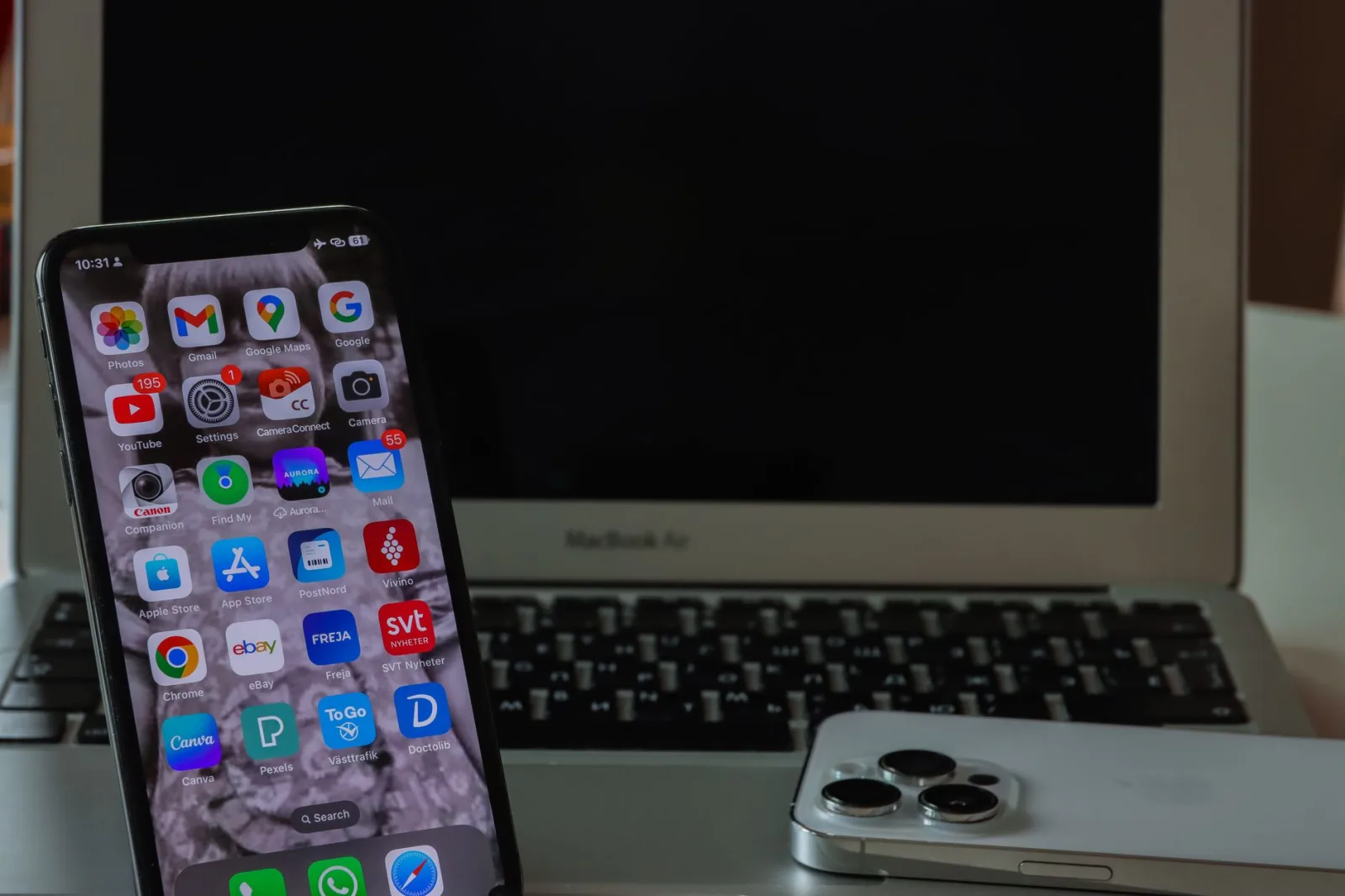 Primer plano de un teléfono inteligente y una computadora portátil sobre un escritorio, que muestran productividad y conectividad.