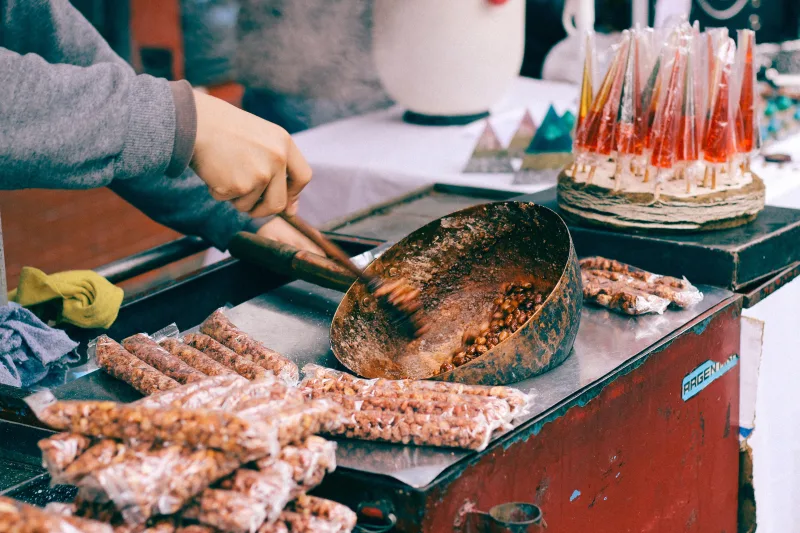 Street vendor preparing candied peanuts at a market in Buenos Aires, Argentina.