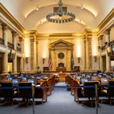 Una majestuosa cámara gubernamental con elegantes columnas y asientos. Ideal para temas de política o arquitectura.