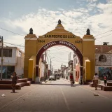 Street view of the archway in San Pedro de Lloc, Peru, showcasing vibrant urban life.