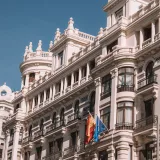 Classic architectural facade along Madrid's Gran Vía under a clear blue sky.