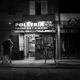 Black and white photo of a chicken shop at night in Córdoba, Argentina, showcasing urban nightlife.