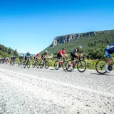 Professional cyclists speed through mountainous terrain in Mersin, Türkiye on a sunny day.